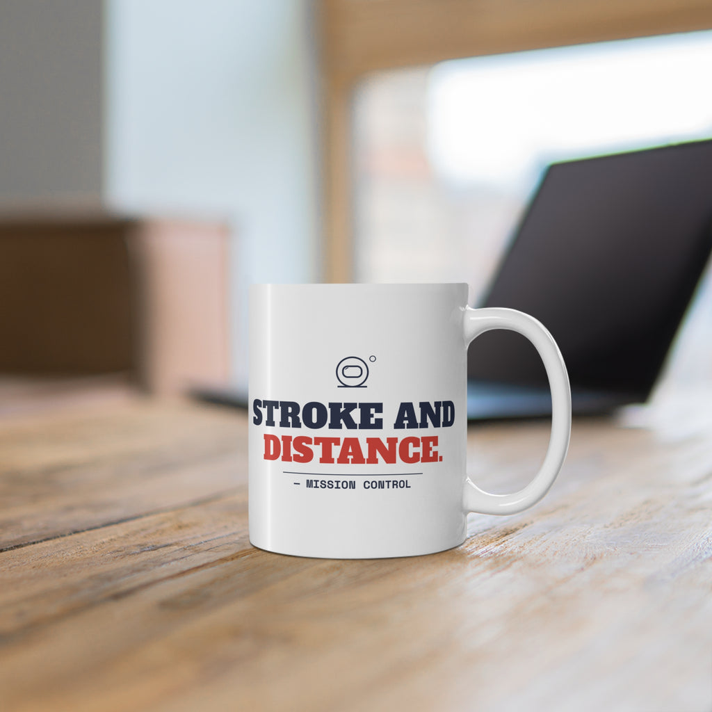 Stroke and Distance golf mug on a wooden desk next to a laptop